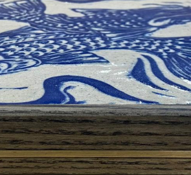 edge detail showing close up of stained ash frame with brass stripe detail and Persian Carp design sgraffito tile
